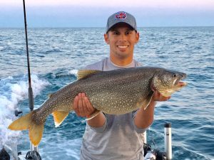 Jordan Rodriguez holding a large mackinaw trout