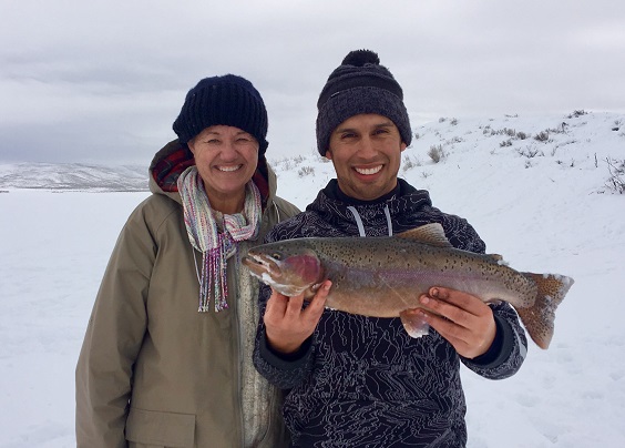 Jordan Rodriguez and a happy student show off a large rainbow trout they caught during an Ice Fishing 101 class