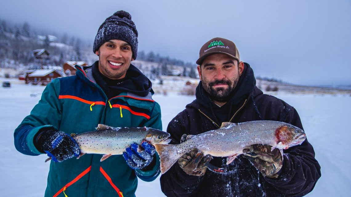 Jordan Rodriguez and a happy student holding large trout on an ice fishing trip
