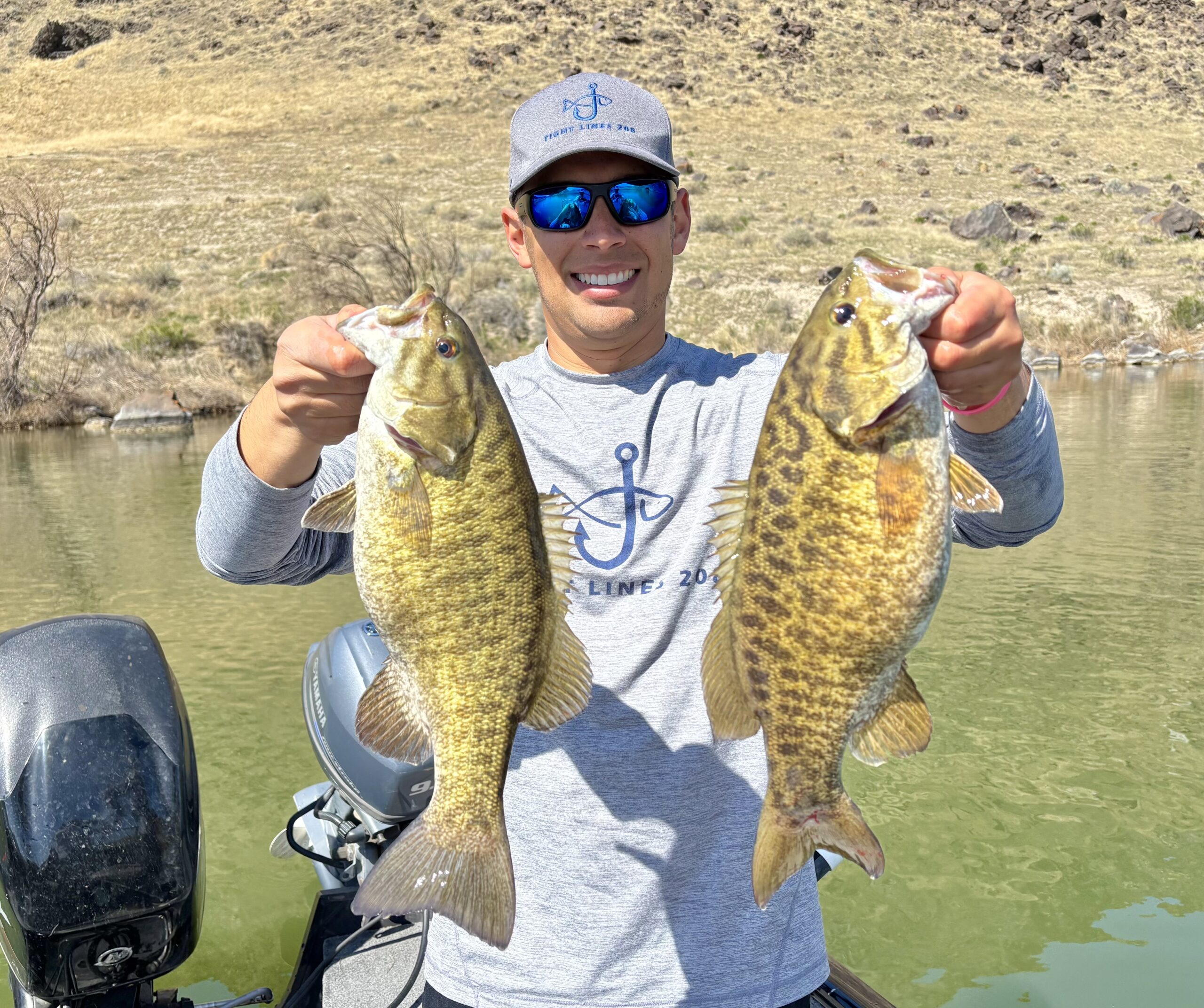 Jordan Rodriguez holding two big smallmouth bass.