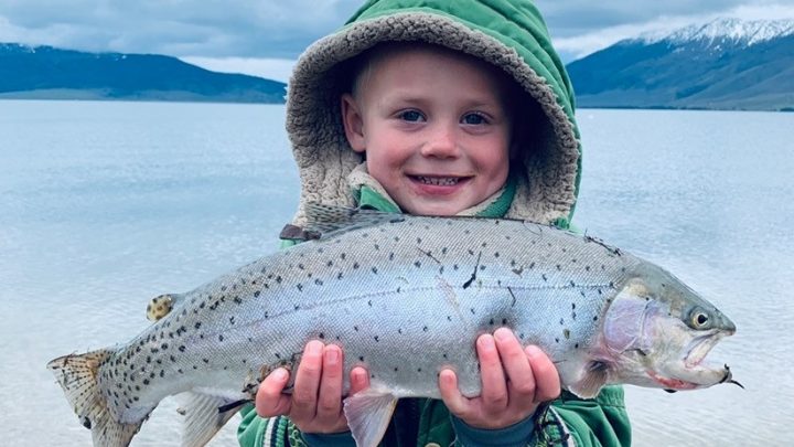 Young boy holding a large cutthroat trout at Henry's Lake in Idaho