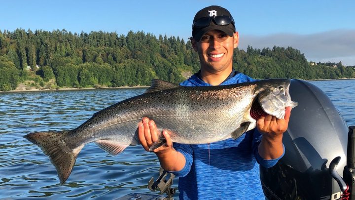 Jordan Rodriguez holding a large Chinook Salmon.
