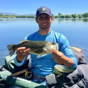 Jordan Rodriguez shows off a largemouth bass caught on a fly rod
