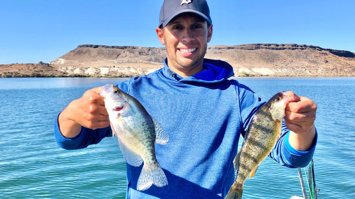 Jordan Rodriguez holds a crappie and a perch caught at C.J. Strike Reservoir.