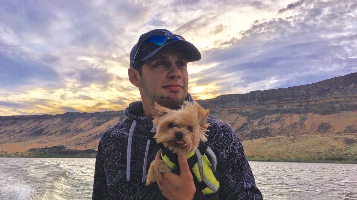 Jordan Rodriguez boats through the Snake River Canyon holding his best fishing buddy, Yorkshire terrier Winston