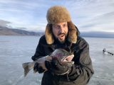 Justin Dalme shows of a large cutthroat trout caught through the ice at Henrys Lake