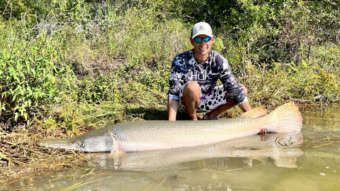 Jordan Rodriguez with a 130-pound alligator gar he caught on a road trip in Texas