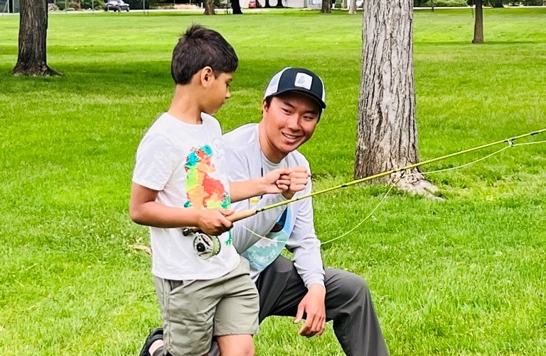 A young boy takes instruction from a Mayfly Project mentor in Boise