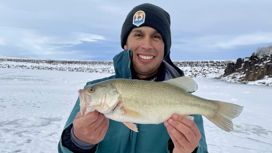 Jordan Rodriguez with an 18-inch largemouth bass caught through the ice.