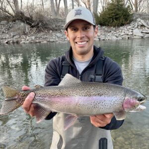 Jordan Rodriguez holds a large rainbow trout caught on the Boise River