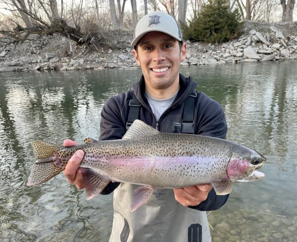 Jordan Rodriguez holds a large rainbow trout caught on the Boise River