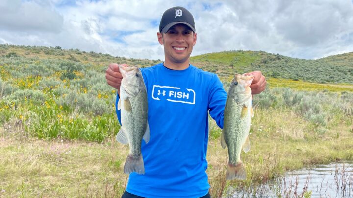 Jordan Rodriguez shows off two largemouth bass he caught on a June fishing trip.