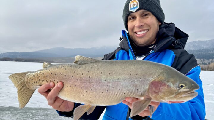 Jordan Rodriguez holding a large Yellowstone cutthroat trout caught through the ice at Henrys Lake