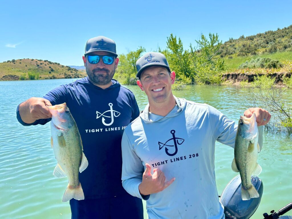 Two anglers wearing Tight Lines 208 fishing hoodies.