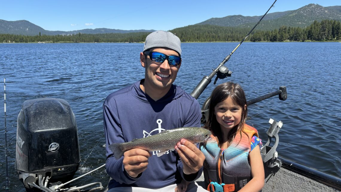 Two anglers holding a trout at Horsethief Reservoir