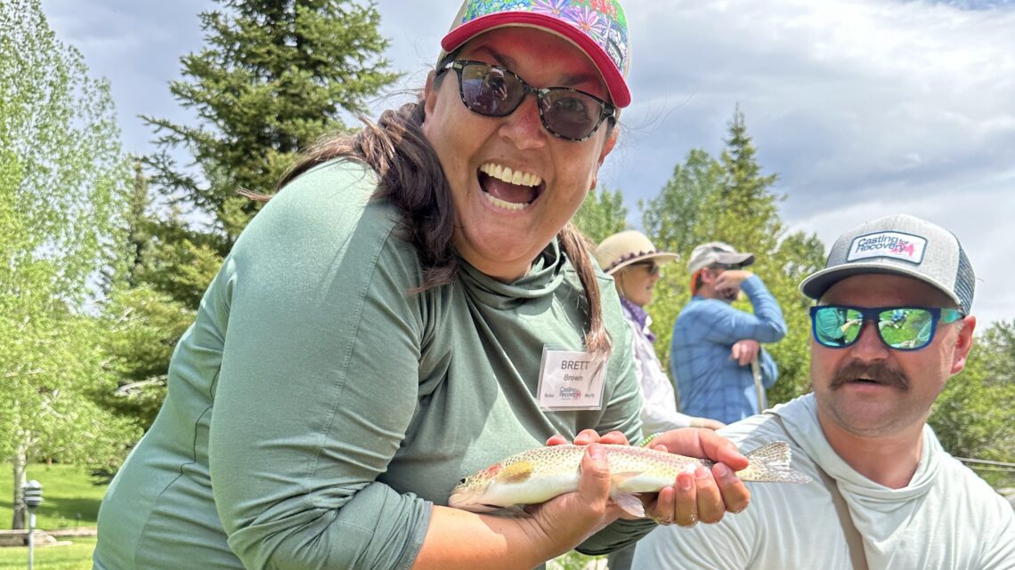 A Casting for Recovery participant shows off a trout caught on a fly.