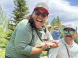 A Casting for Recovery participant shows off a trout caught on a fly.