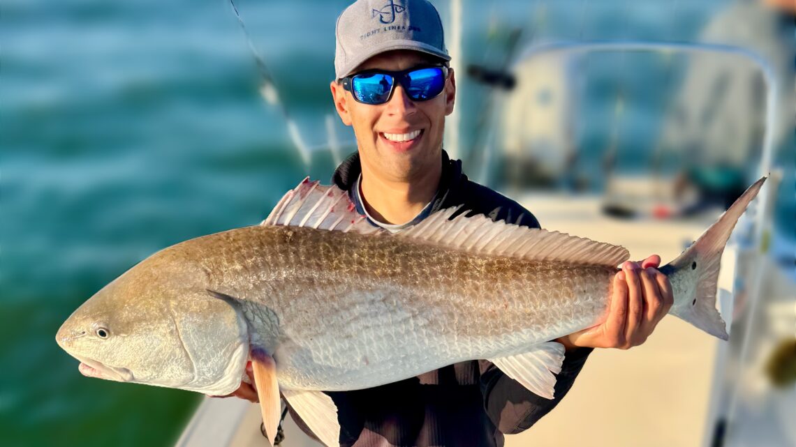 Jordan Rodriguez holding a 40-inch redfish caught off the coast of North Carolina.